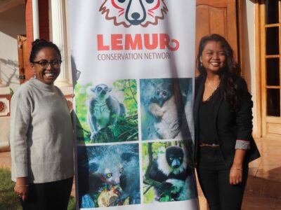 Seheno and Misa in front of the Lemur Conservation Network banner