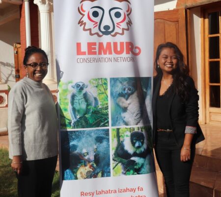 Seheno and Misa in front of the Lemur Conservation Network banner